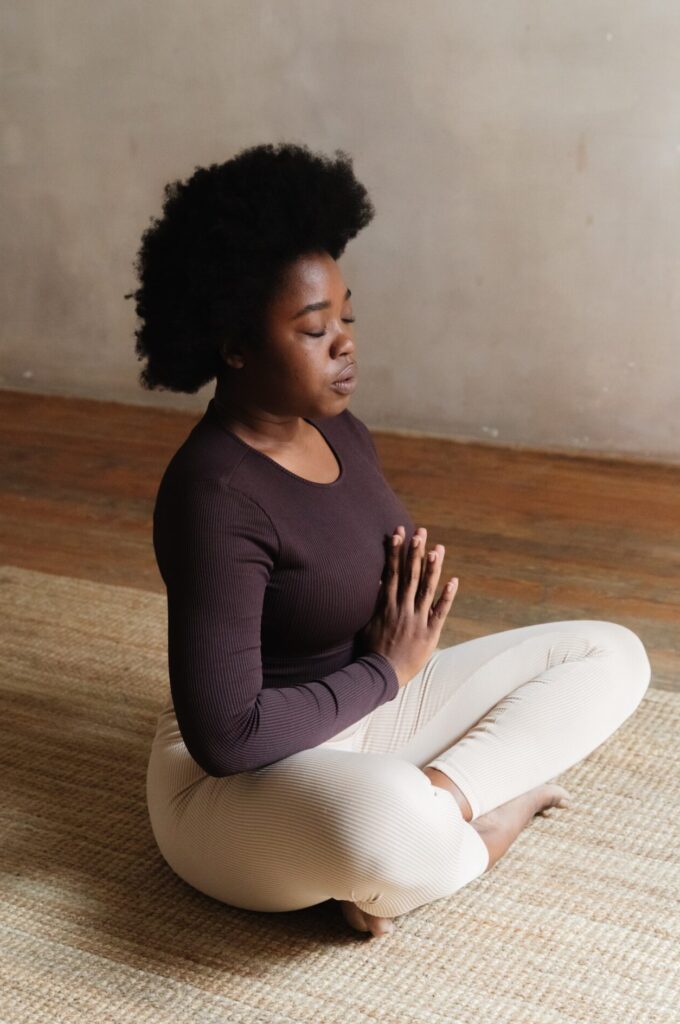 Mulher sentada com as pernas cruzadas, meditando